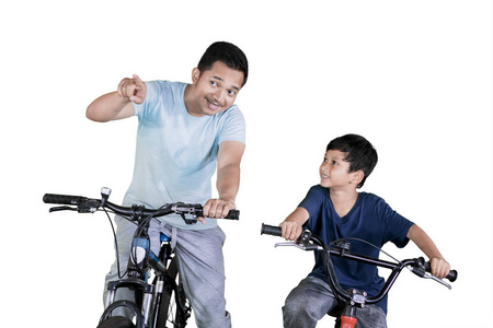 年轻人在画室里和儿子骑自行车时指着什么东西的照片