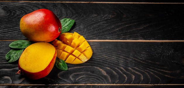 芒果。 热带水果上的黑色木制背景复制空间文本空白的文本顶部视图。