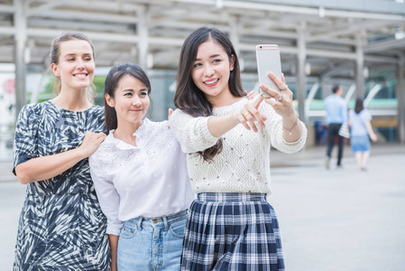 三个年轻女人用智能手机自拍