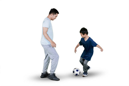小男孩和他的父亲在画室里踢足球的画面被孤立在白色背景上