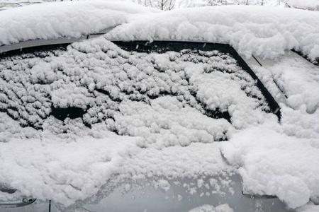 汽车上覆盖着厚厚的一层雪。 大雪的负面后果。 汽车的左边被雪覆盖