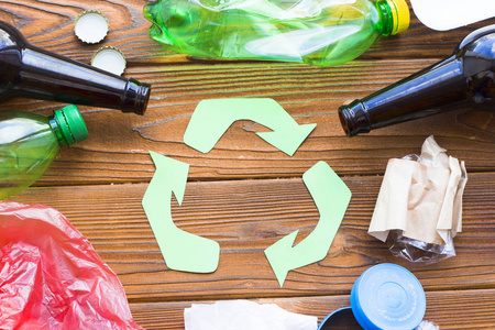 环保生态与循环利用概念回收标志与垃圾在深色木制背景上特写
