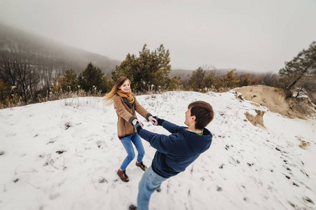 快乐的一对情侣在雪地冬季公园玩得开心