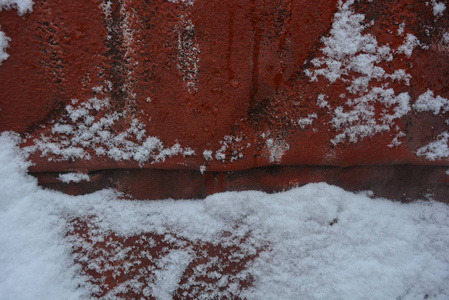 冬天的背景，雪，雪，美丽的切割，在一张金属建筑板上，涂上旧的红色油漆，上面有土丘和山谷