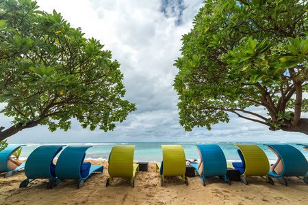 在印度尼西亚巴厘岛努沙杜瓦海滩的海景和热带海滩与树木和日光浴床