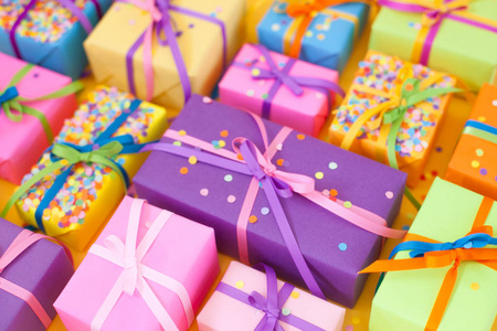 带有彩色丝带的彩色礼品盒。 黄色背景。 圣诞节或生日礼物。