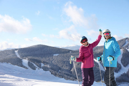 带着滑雪设备的幸福夫妇在山里度寒假。 文本空间