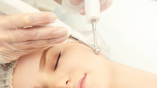 面部微电流美容程序。 美容技术治疗。 女性面部治疗。