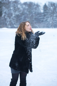 公园里的女孩很高兴和雪玩