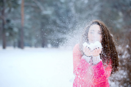 年轻漂亮的女人手中吹着雪