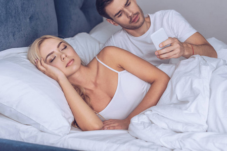 在女朋友睡觉时使用智能手机的可疑青年