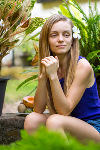 有热带植物的年轻女子在花园里冥想