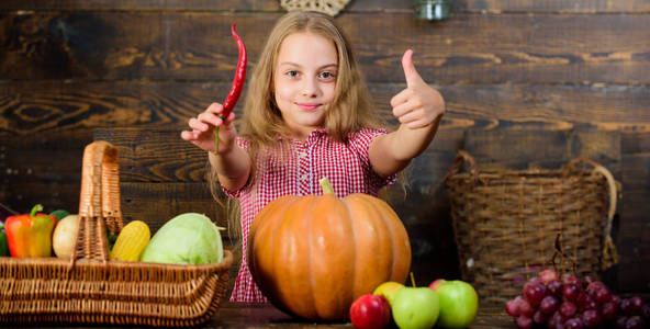 女孩孩子在农场市场与秋天收获。小女孩庆祝收获。家庭农场节日的概念。孩子农夫以收获木背景。农场为孩子们举办的主题游戏和活动