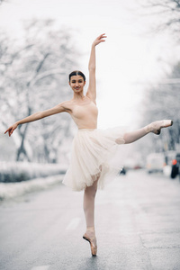 穿着透明裙子的美丽芭蕾舞女演员正在中街跳舞。