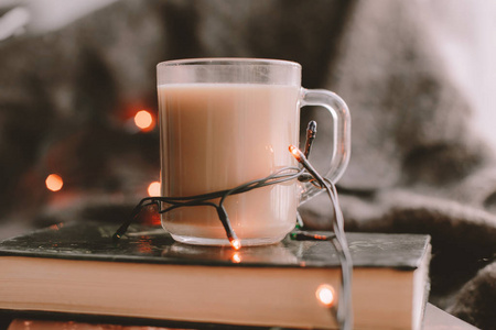 透明杯子里的咖啡在书上是值得的。 窗台上的咖啡书和毯子。 心在冻结的窗户上。 一个舒适的冬日，有咖啡和书。