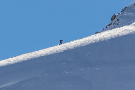 滑雪登山者爬上高山岭