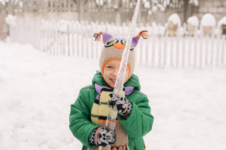 一个带冰柱的小男孩的冬天画像