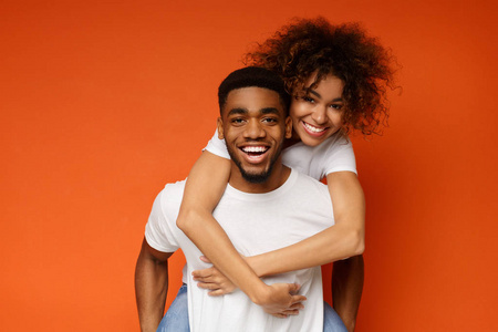 非洲裔美国夫妇在橙色背景的乐趣