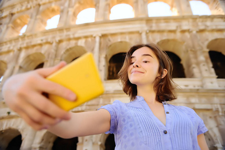 年轻的女性旅行者在意大利罗马的竞技场上拍摄自拍照片。 意大利观光旅游。
