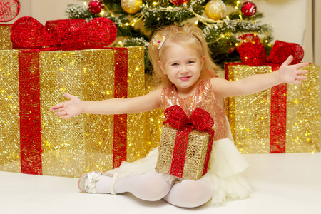 带着礼物在圣诞树附近的小女孩