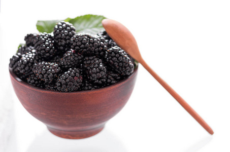 黑莓在粘土盘子里。 白色背景。 新鲜浆果。