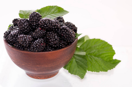 粘土盘子里的黑树莓。 黑树莓和叶子。 隔离隔离