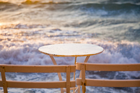 日落时靠近海浪的桌椅海滩度假