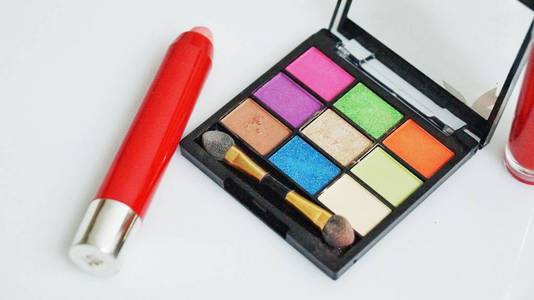 化妆和化妆品的工具，不同色调的眼影调色板和化妆刷的白色背景。 特写和选定的焦点。