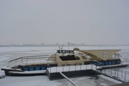 浮动餐厅船停泊在DNIP RO河畔。 冬天的霜冻天气有雪和冻水