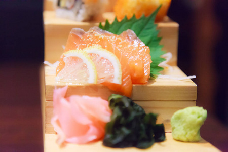 日本鲜鱼美食菜，菜单三文鱼刺身，海藻，生姜和芥末装饰在传统的日本餐厅的木制台阶上。 营养丰富的健康食品，美味的膳食概念