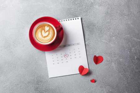 情人节贺卡。 红色咖啡杯和礼品盒超过二月日历。 上面的风景。