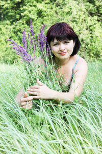 年轻女子带着鲜花来到草地上