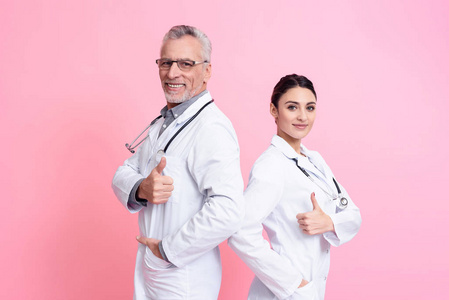 微笑的男性和女性医生的肖像与听诊器提供竖起大拇指隔离