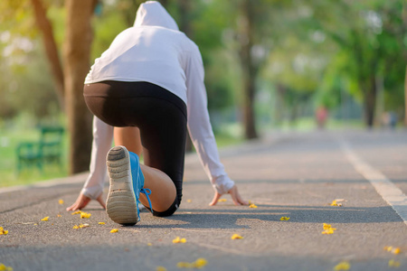 年轻的健身妇女在公园散步，户外女跑步者在亚洲运动员以外的道路上跑步，在阳光明媚的早晨在小径上慢跑和锻炼。 体育健康与健康概念