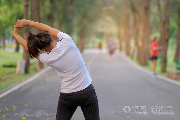 户外女跑步者热身,准备在亚洲健身以外的道路上慢跑,早上在人行道上