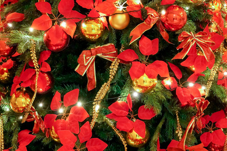 关上圣诞树上的圣诞装饰品。在圣诞节和新年期间，在绿色圣诞树背景装饰上选择性地聚焦黄色和红色彩色球。