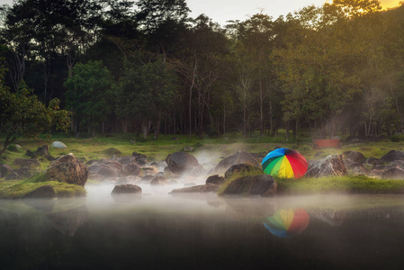 日落场景中有五颜六色的雨伞的温泉景观。 国家公园地热天然蒸汽。 旅行目的地。