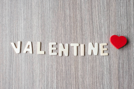 情人节字的木制字母字母，红色心形在桌子背景上。 浪漫浪漫爱情概念
