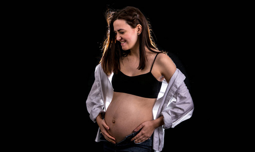 怀孕妇女肖像的黑色背景概念怀孕和预期的孩子