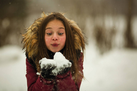 情感女孩在冬天在户外玩雪。
