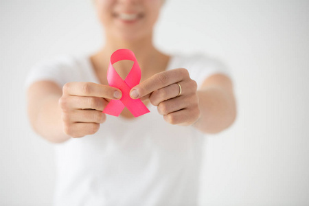 s hans holding pink ribbon as a sing of support for women with b