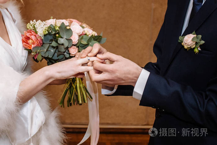 新郎戴着结婚戒指给新娘.