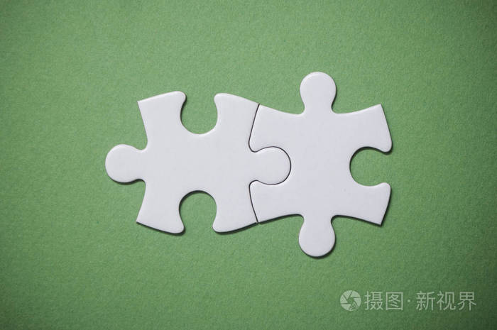绿色背景上的两个连接的拼图块.