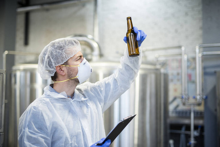 技术人员检查啤酒厂的啤酒质量。 酒精饮料的生产。