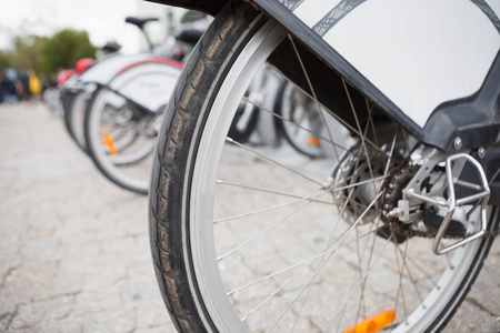 自行车轮停在城市街道的停车场。城市交通以供出租。绿色动力转换。点击踏板和骑城市街道快速和安全