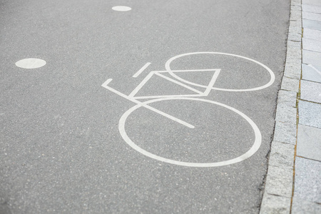 户外公园沥青上白色油漆自行车道标志。 健康生态运输的独立途径