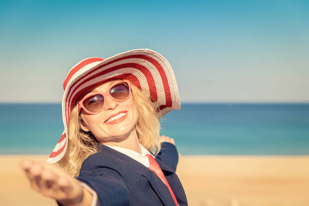 海滩上成功的女商人。 年轻女子在海天的背景下。 暑假和自由旅行概念