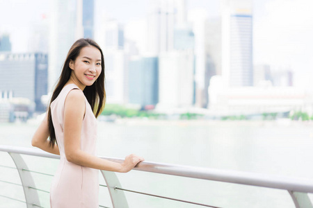美丽的亚洲女人微笑，快乐地在新加坡城市旅行