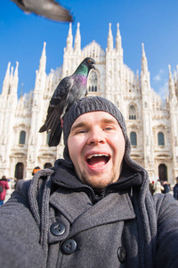 旅行, 假期和寒假概念快乐的人采取自拍照片与有趣的鸽子在大教堂米兰大教堂前
