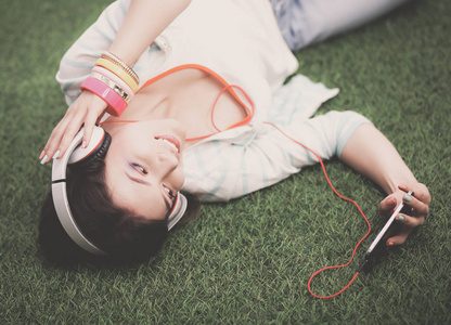 听音乐躺在绿草地上的女人